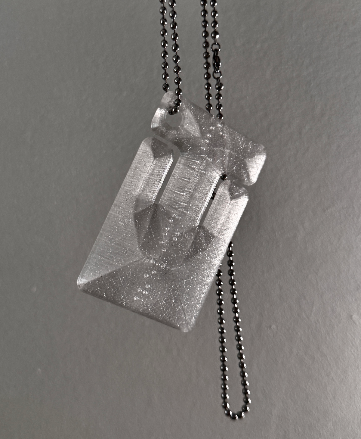 cable frame crystal hanging by its ball chain, light shining through