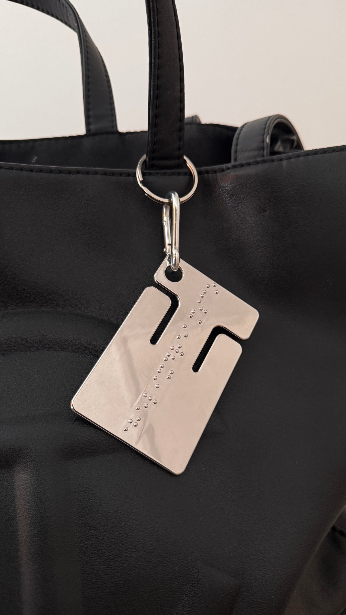 cable frame chrome clipped to a black tote bag
