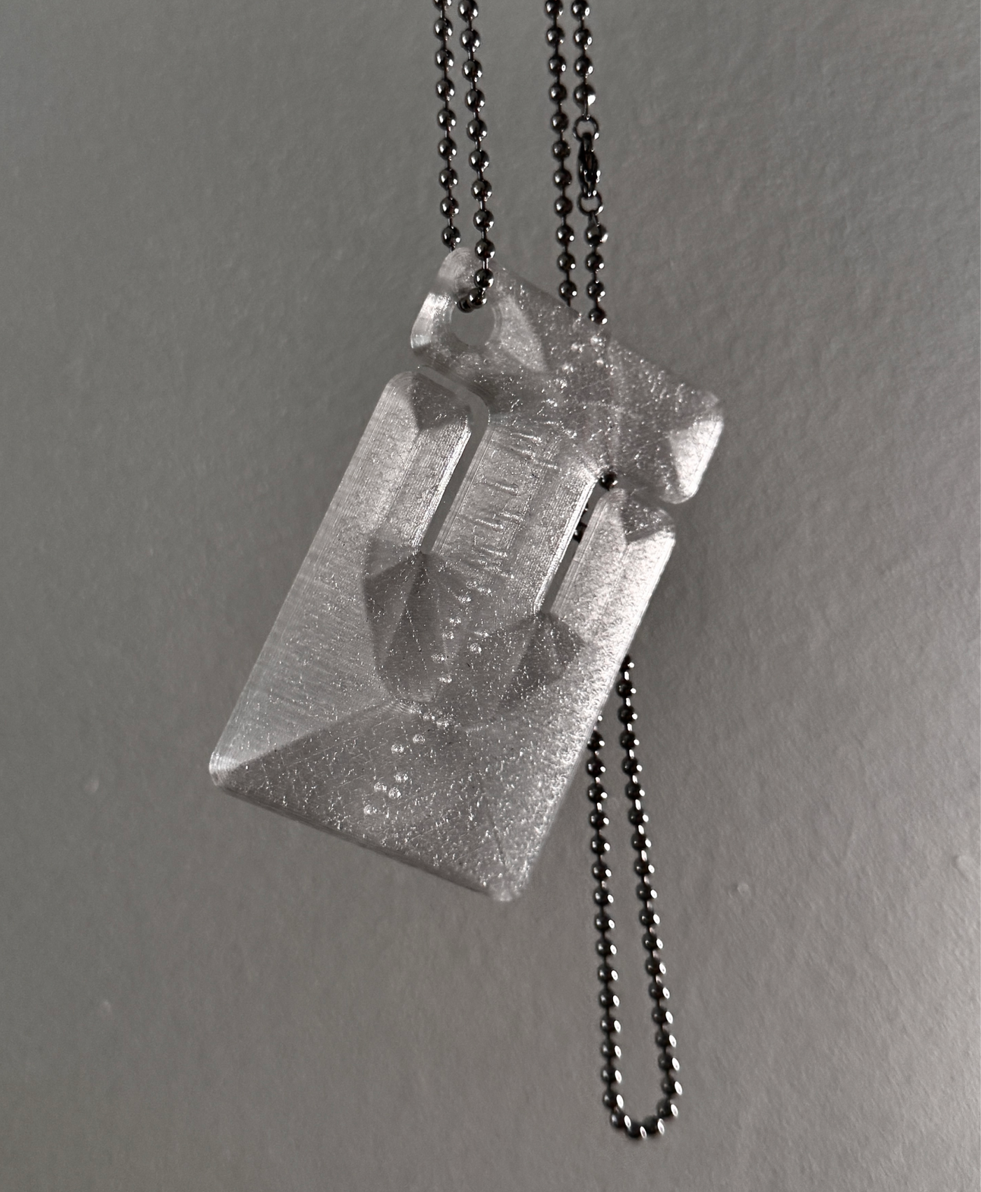 cable frame crystal hanging by its ball chain, light shining through
